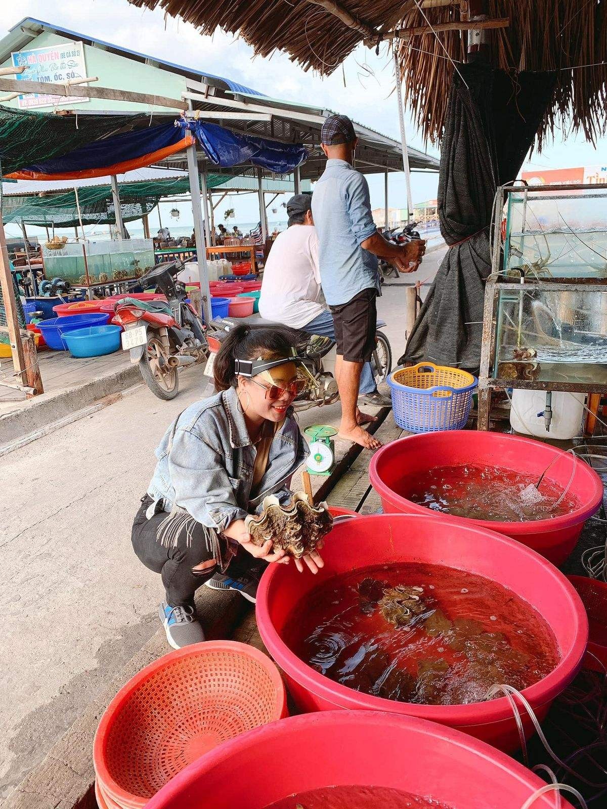 Du khách đang tự tay lựa chọn những con sò tươi ngon tại một gian hàng hải sản ở chợ Hàm Ninh