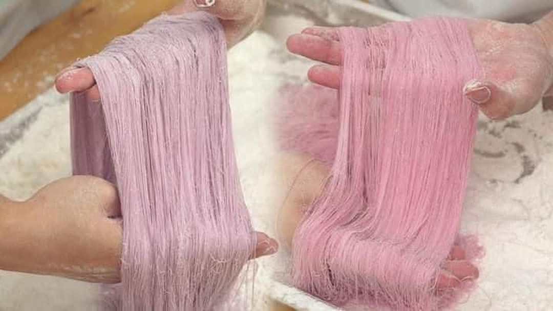 Người thợ đang thực hiện công đoạn kéo sợi đường thành kẹo chỉ mỏng manh