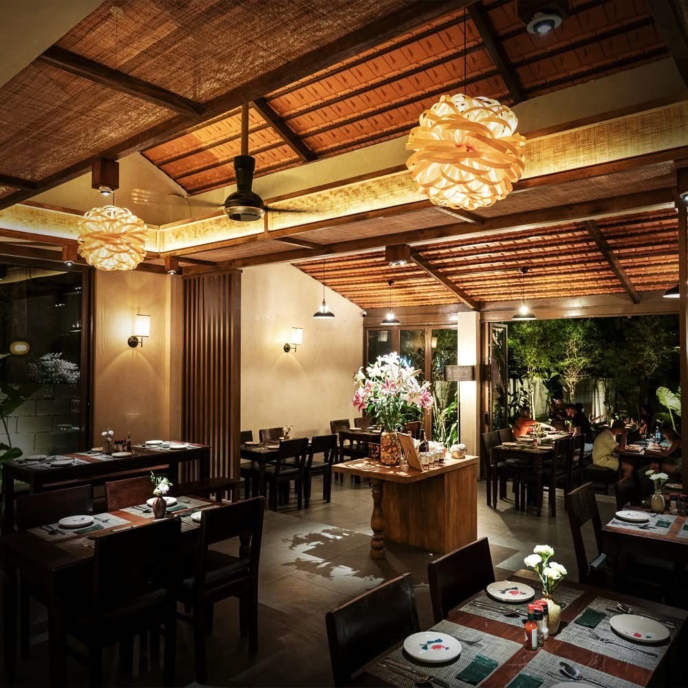 Không gian ấm cúng bên trong nhà hàng The Home Pizza Phú Quốc với tường gạch mộc và đèn trang trí